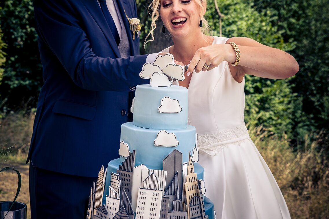 Un uomo e una donna tagliano una torta nuziale