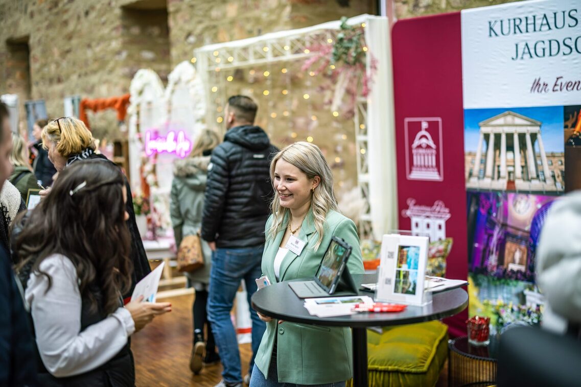Eine Frau steht am Messestand und redet mit einer Kundin