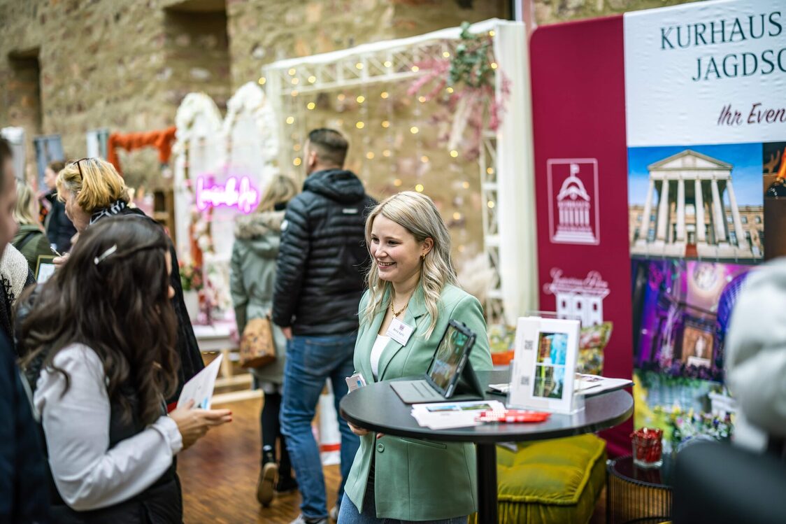 Eine Frau steht am Messestand und redet mit einer Kundin