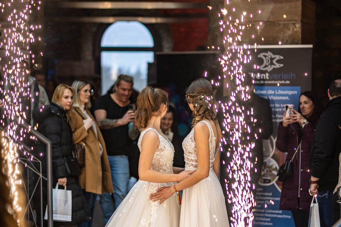 Zwei Frauen stehen und haben Hochzeitskleider an