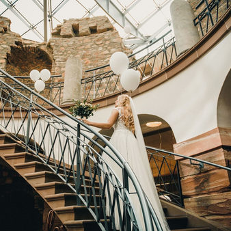 Braut im Hochzeitskleid geht die Treppe hoch