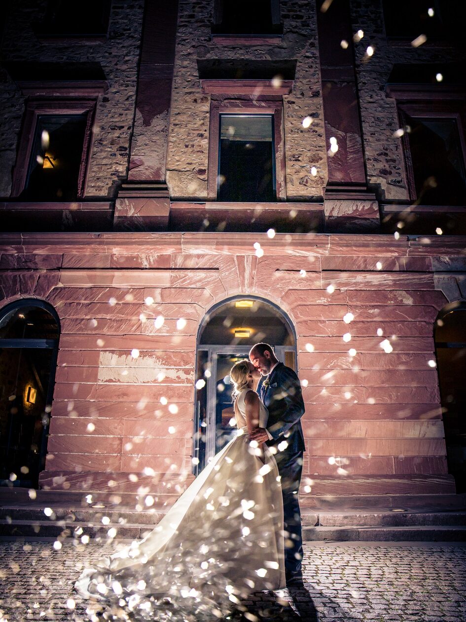 Una sposa e uno sposo si baciano davanti all'ingresso principale del Platte Hunting Lodge