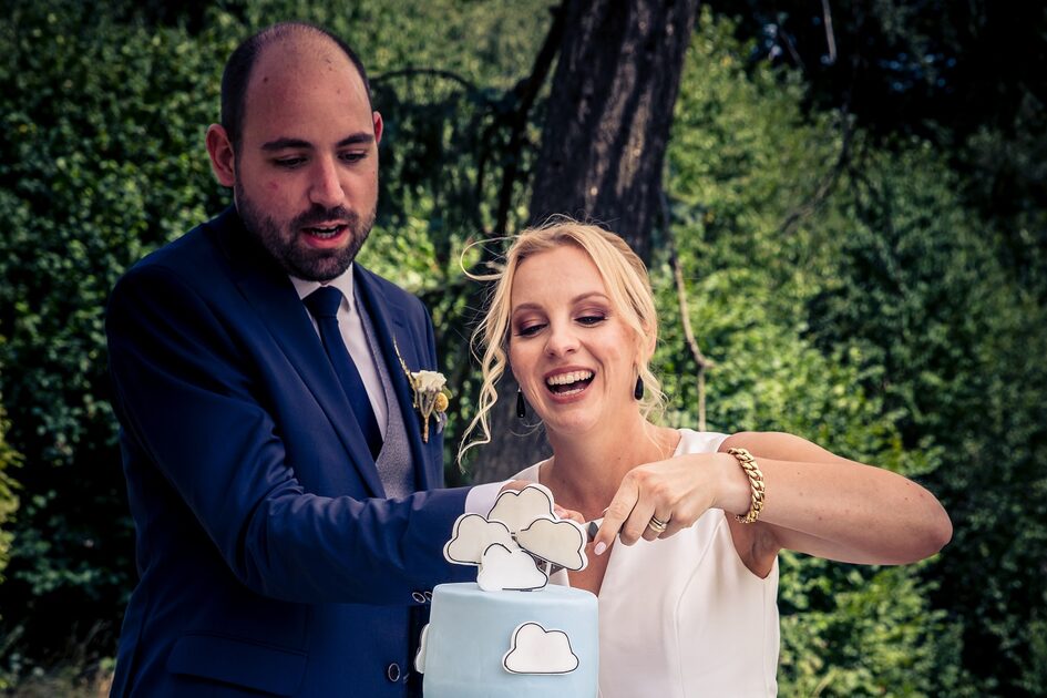 Un uomo e una donna tagliano una torta nuziale
